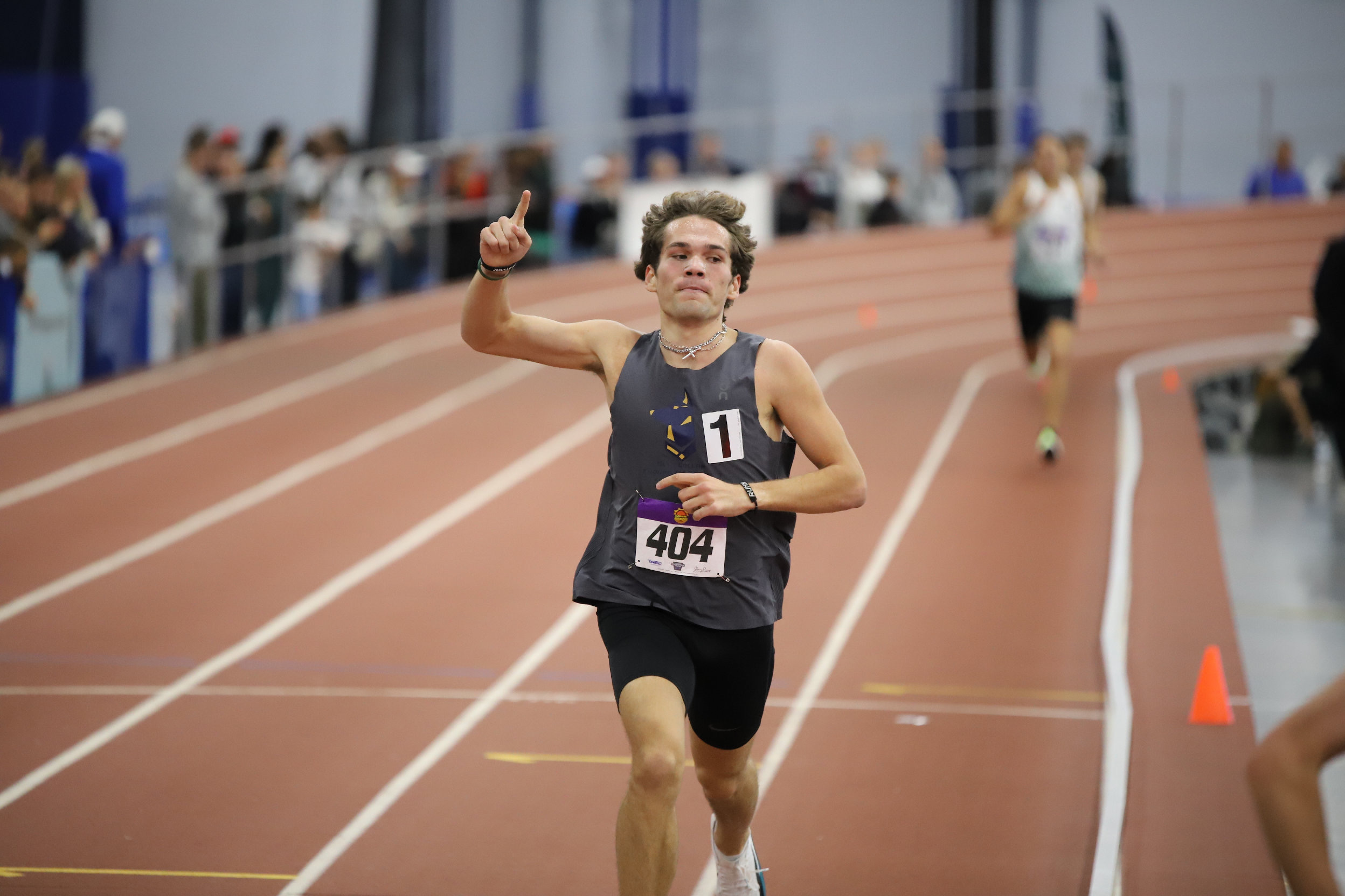 A BCET athlete winning an indoor track race