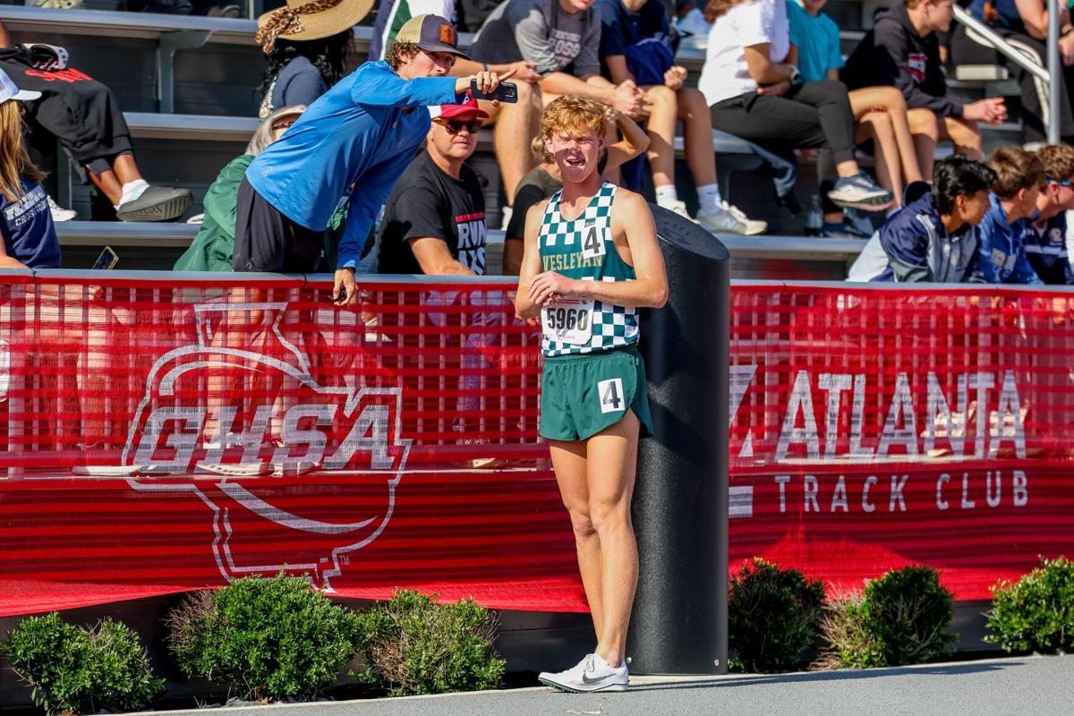 A BCET coach pointing out the race to an athlete at the state meet
